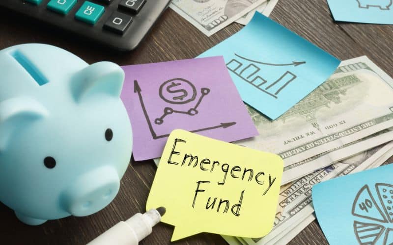 Image showing a piggy bank, some money, sticky notes and a text that read emergency Fund