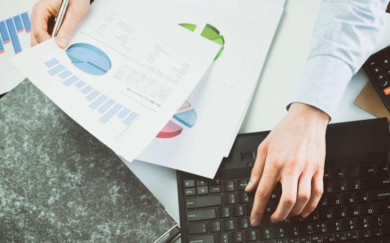 Business woman reading or inspecting financial documents on her desk