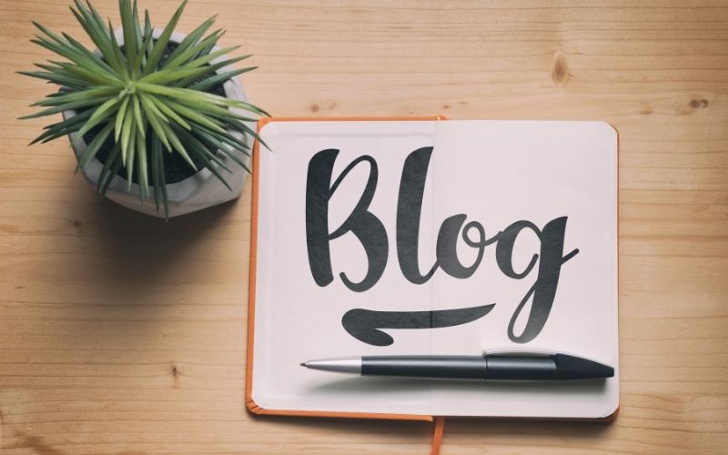 blogging concept with a notebook on the wooden desk