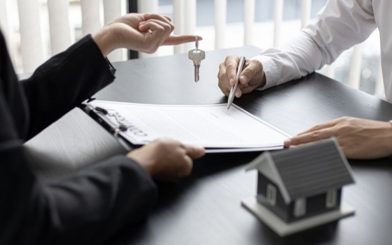 investor signing the contract and real estate agent holds the keys