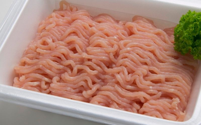 Photo of a finely ground fresh turkey in a white plastic container