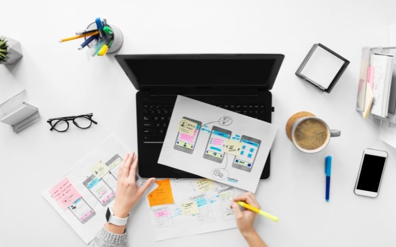 webdesigner with sketches and laptop