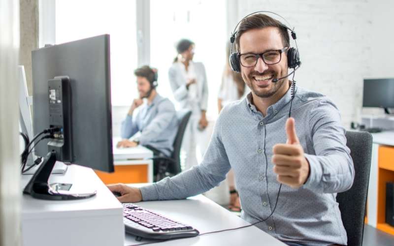 male customer service operator showing thumb up in office