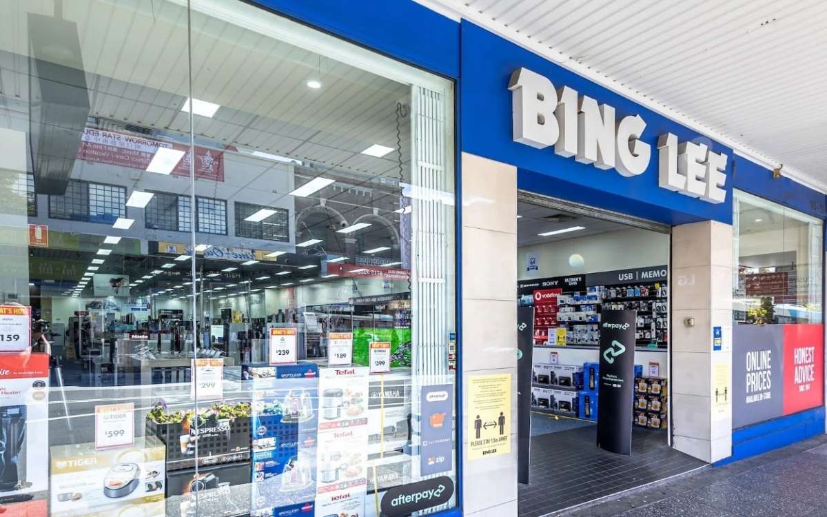 A store that sells appliances with large glass display windows and glass doors with text that reads Bing Lee placed above the entrance 