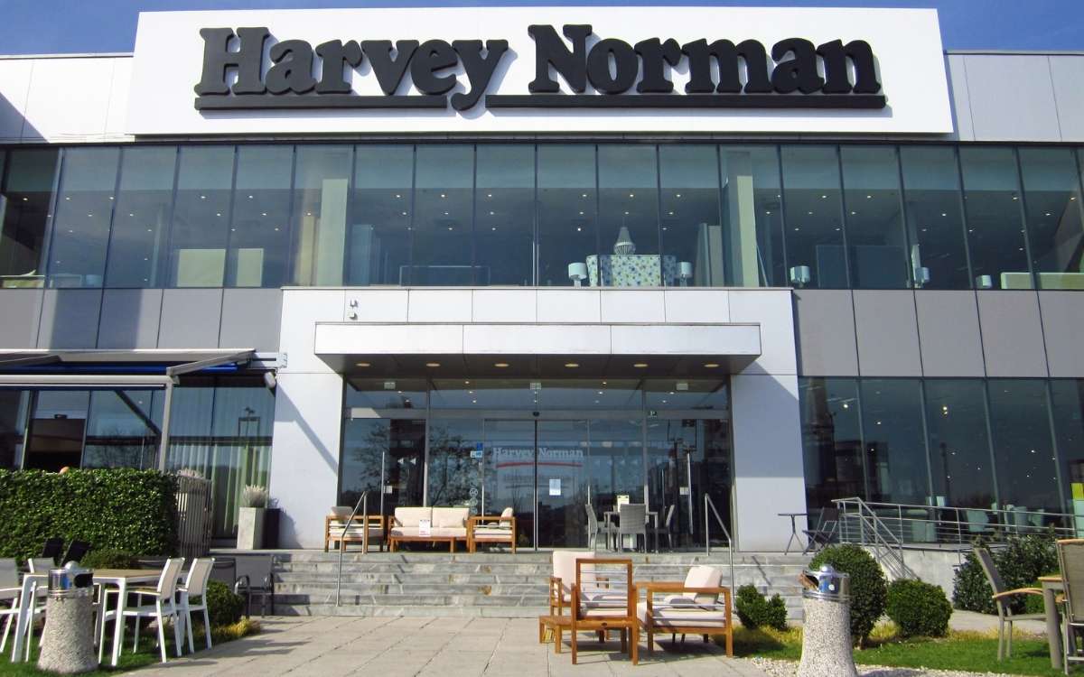Photo of a large shopping store displaying several home furniture and a text sign that reads Harvey Norman above the entrance.