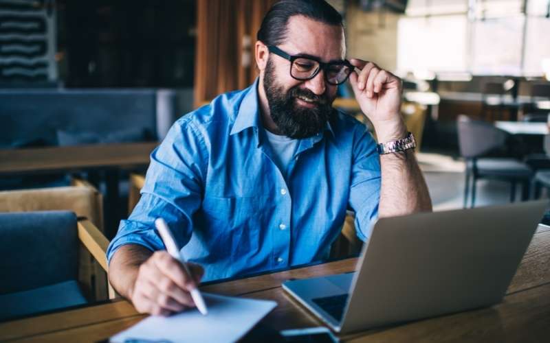 male freelancer writing on paper