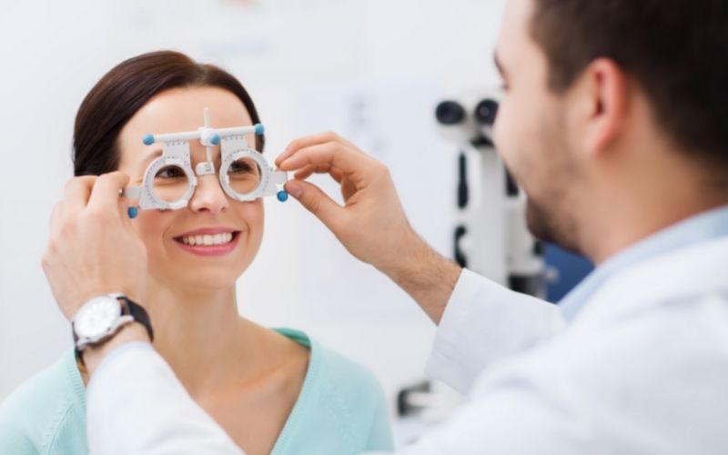 optometrist with trial frame checking patient vision