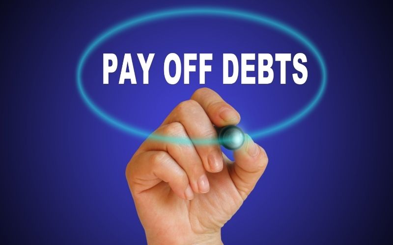 a handwriting word pay off debts with a marker on gradient background