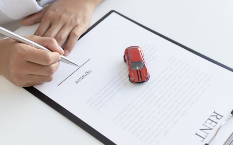 person signing car rent agreement document