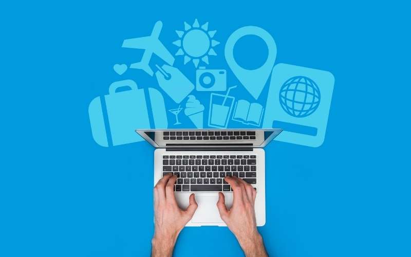 male hands typing on a laptop, travel concept background
