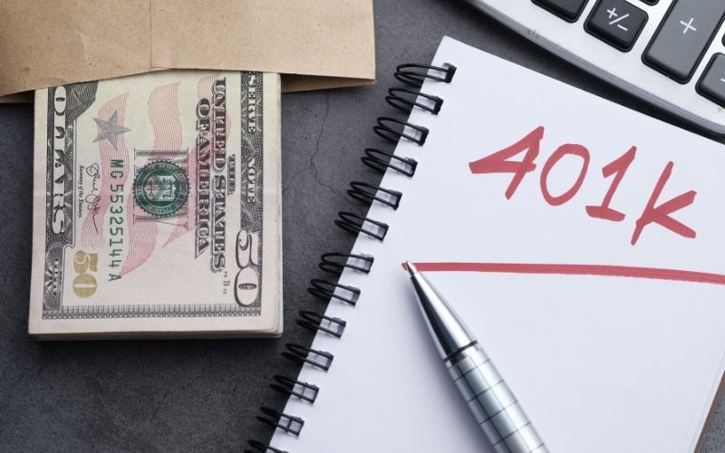 401k word written on notepad with dollar on table